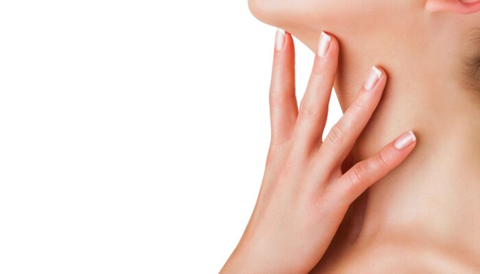 Skin care Closeup of a young woman regards her neck isolated on white background